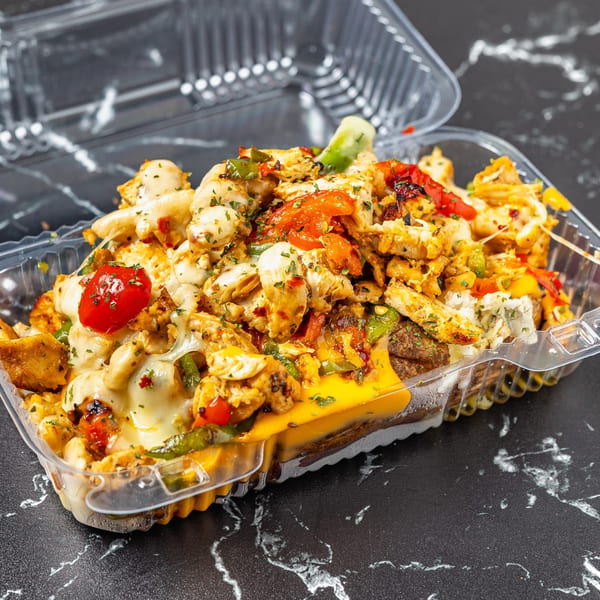 A Watta Potato dish with chicken, melted cheese, and vegetables in a clear takeout container.